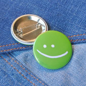 Ansteckbutton Smiley grün auf Jeans mit Rückseite